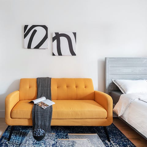 Sink into the statement mango-coloured sofa with a magazine