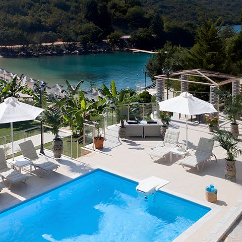 Lounge poolside with picture-perfect views across the cove