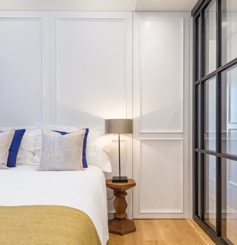 A cosy bedroom with a glass wall