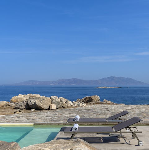 Admire the rocky coastline of the Greek islands from the pool