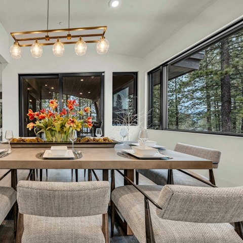Enjoy a leisurely meal at the dining table with pine forest views beyond