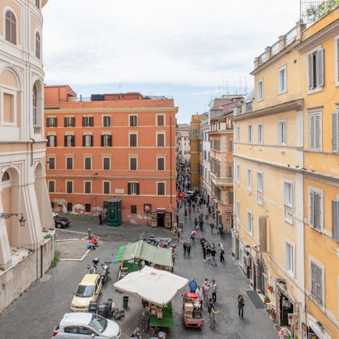 Watch the bustling Roman street scenes from the window