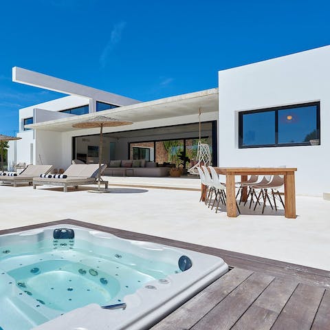 Pour a glass of something sparkling and relax in the outdoor hot tub