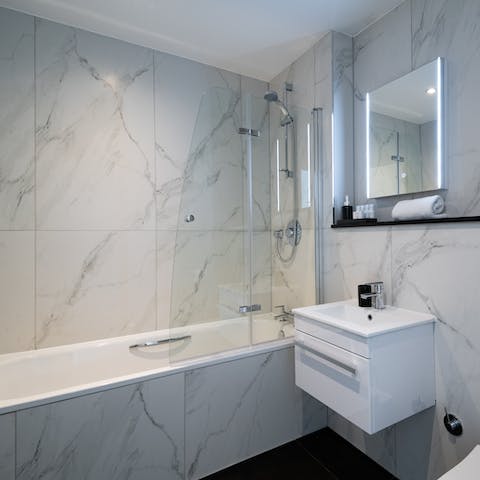 Take a relaxing soak in the modern marble-effect bathroom