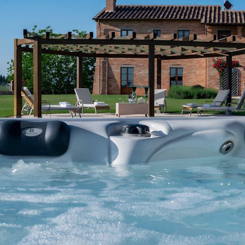Unwind in the jacuzzi hot tub with a glass of local Italian wine in hand