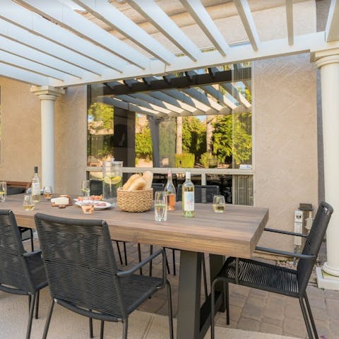 Enjoy glorious feasts in the shade at the chic dining table