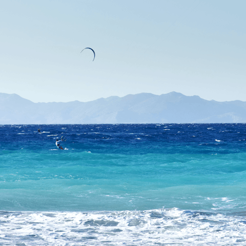 Try your hand at kite surfing on Kremasti Beach
