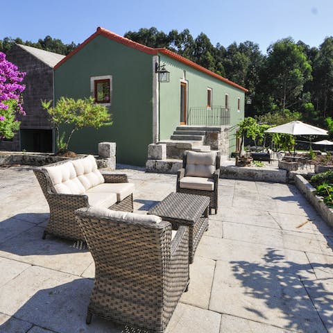 Savour your refreshing morning coffee on the patio, overlooking the verdant landscape from the comfy outdoor sofa