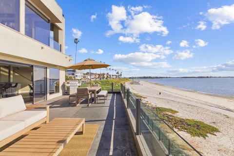 Dine alfresco steps from the sand with unbroken bay views