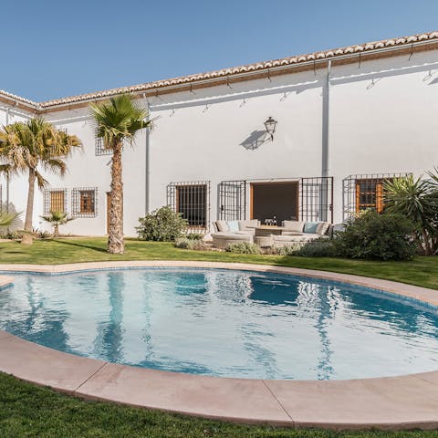 Swim in the glistening pool surrounded by tropical plant life