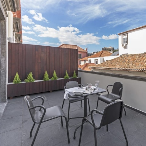 Enjoy a Madeiran feast on your private terrace with views over the terracotta rooftops of Funchal