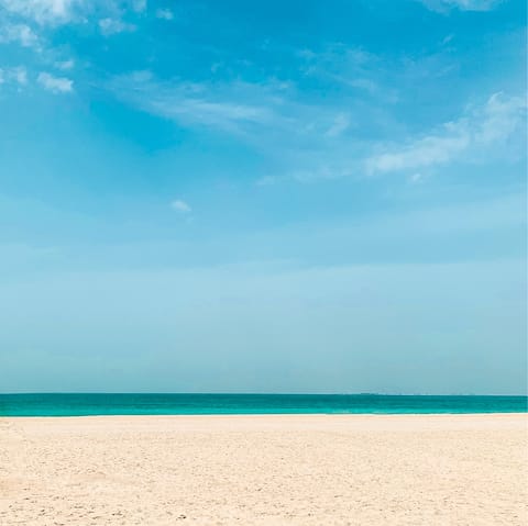 Sink your toes in the sand at Palm Jumeirah Beach, a one-minute walk away