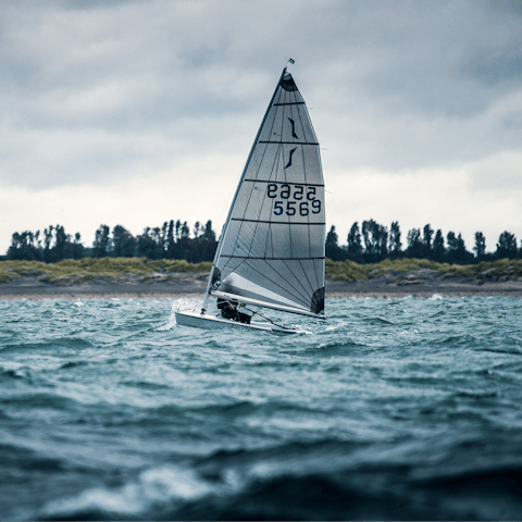 Set sail against a clear sky, with white sails billowing