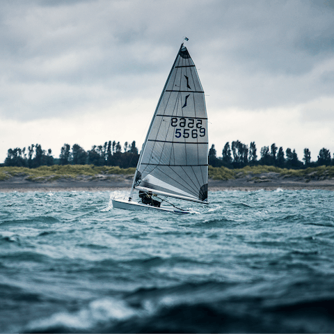 Set sail against a clear sky, with white sails billowing