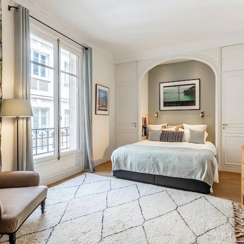 Peer out from the Juliet balcony doors onto the grand Haussmann facades
