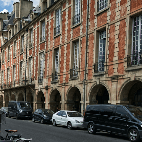 Visit the Place des Vosges, a walk or short ride away