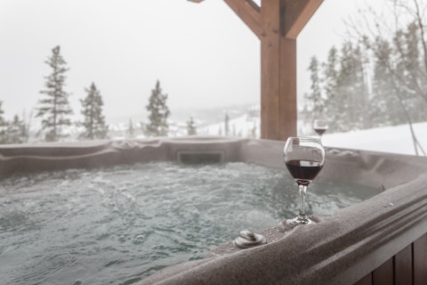 Soak in the hot tub while snow blankets the pine-covered slopes