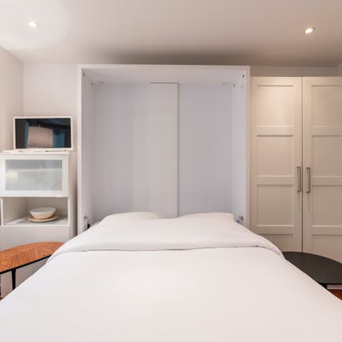Pull down the Murphy bed and transform the living space into a cosy bedroom in the evening