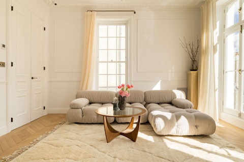 Sink into a tufted sofa beneath original cornicing and tall windows