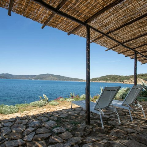 Doze in the shade while listening to the sea lap the shore
