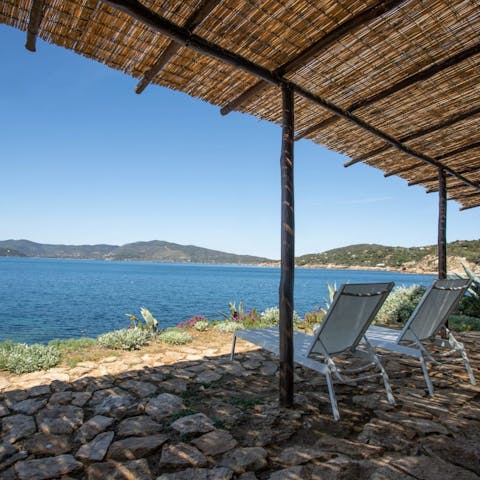 Doze in the shade while listening to the sea lap the shore