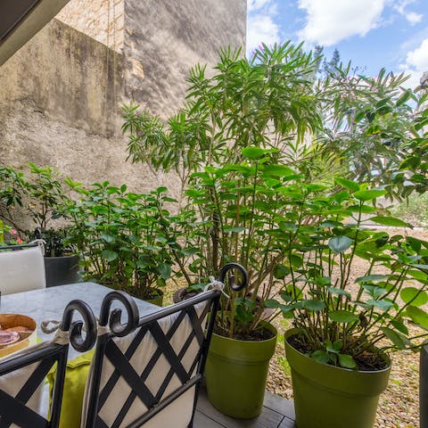 Relax on the terrace with a glass of wine surrounded by lime-hued pots full of shrubs