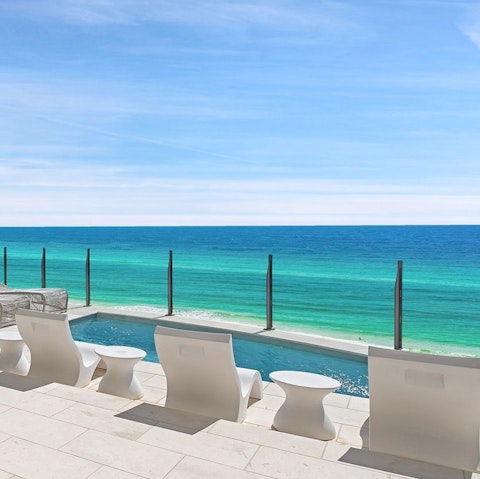 Soak up the sunshine and sea views lying by the pool