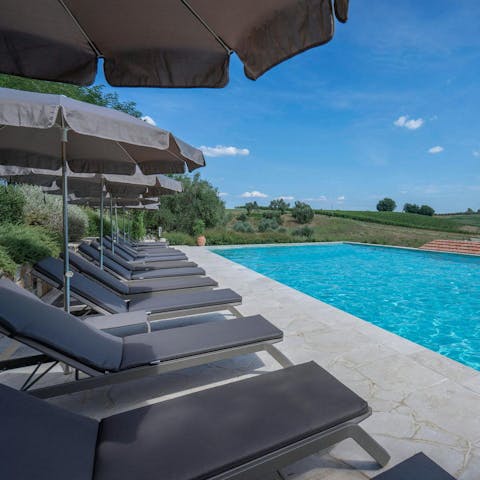 Lounge by the pool with a drink in hand