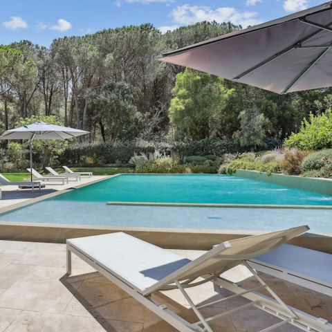 Lounge by the pool with a cocktail and a book