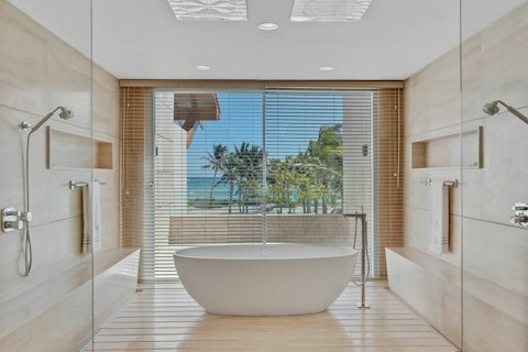 Unwind in the spa-like bathroom with palm-fringed sea views