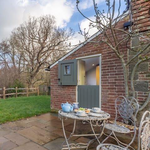 Enjoy afternoon tea on the private patio, overlooking a pond in the garden