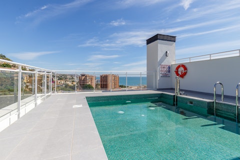 Swim above the Málaga skyline and coast in the shared rooftop pool