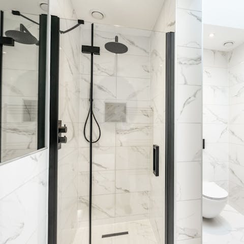 Wash off the day beneath the rainfall shower in the sleek bathroom