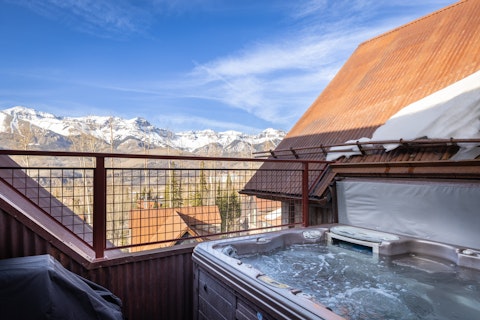 Steam in the hot tub as snow-capped peaks stretch before you
