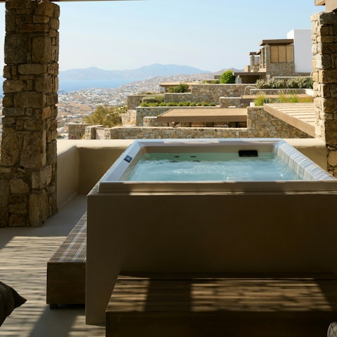 Relax in the shaded hot tub with a panorama of the mountains