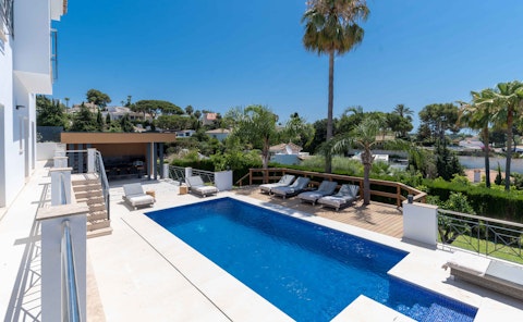 Lounge beside the pool beneath clear Marbella skies