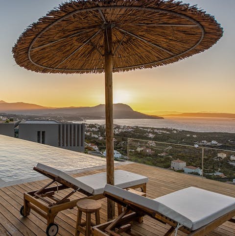 Watch the sun set over the sea while relaxing on a lounger