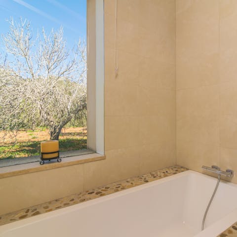 Look out at the beautiful grounds from your bathtub