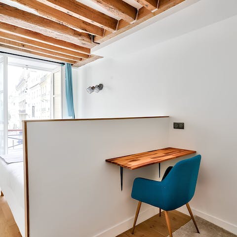 Set up a small workspace in the wood-beamed bedroom