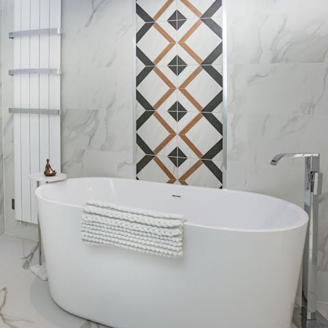 Relax and unwind with a luxurious bath in the sleek bathroom