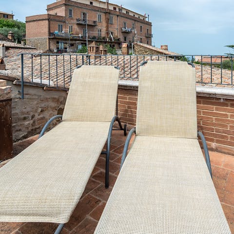 Gaze out at the beautiful Val d'Orcia while lying back on one of the loungers