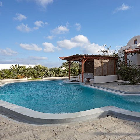 Splash about in the large freshwater pool underneath the Santorini sunshine