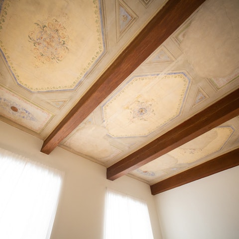 Admire the magnificent original frescoes in the bedroom