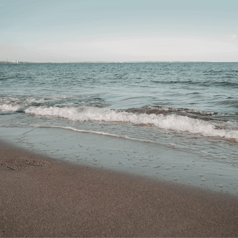 Sink your toes in the sand at Agios Georgios Beach – a ten-minute walk away