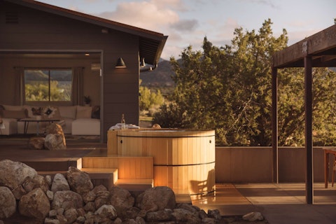 Soak your troubles away in the hot tub as desert mountains glow at dusk