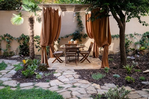 Dine beneath draped curtains in your own walled garden