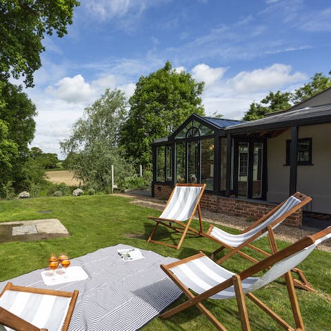 Drink Pimms in the sunshine on festive lawn deckchairs
