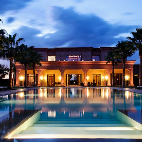 Go for a serene swim under the evening sky in the outdoor swimming pool