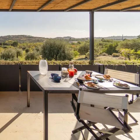 Enjoy breakfast on the rooftop terrace with views out towards the ocean
