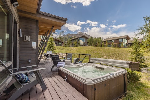 Soak away the day with mountain peaks rising behind you